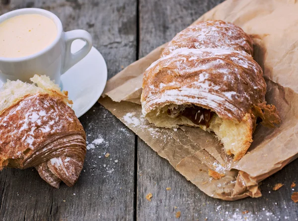 Een kopje koffie "espresso" en croissant op houten tafel. Tonned foto. — Stockfoto