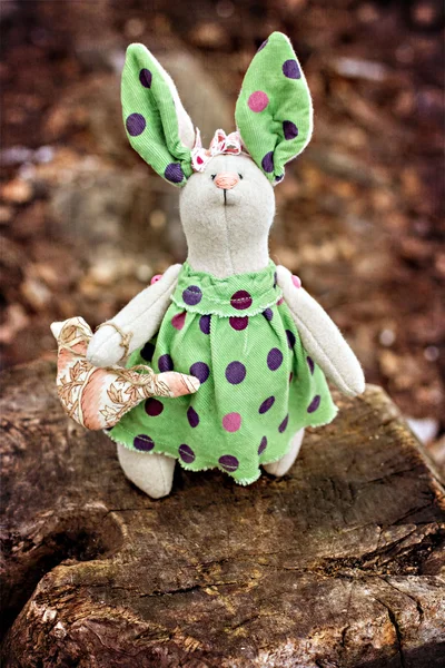 Мягкая игрушка - кролик сидит на старом дереве. тонированное фото — стоковое фото