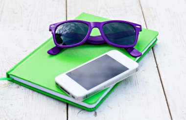 Notebook, mobile phone and sunglasses