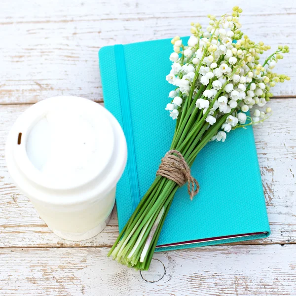 Diary, a glass of coffee and  lilies of valley  on the table — Stock Photo, Image