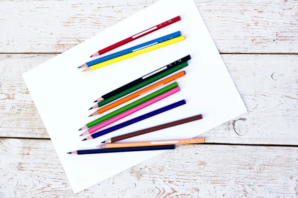 Renkli kalemler ve masada bir kağıdın — Stok fotoğraf
