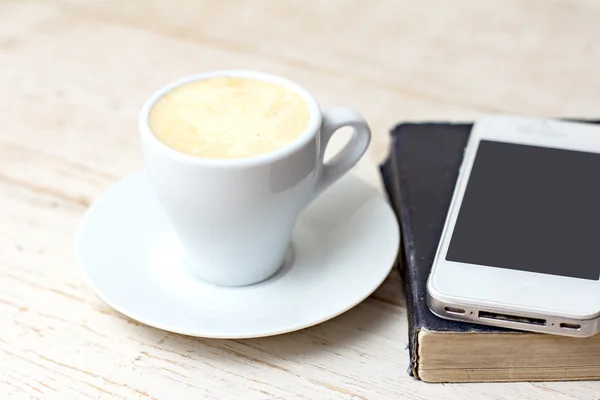 Uma chávena de café "espresso" e um telefone . — Fotografia de Stock