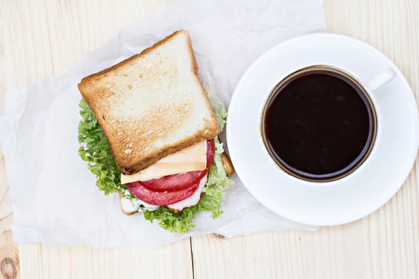 Sandwich y taza de café negro — Foto de Stock