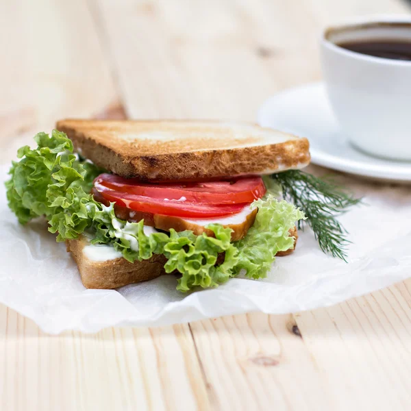 Sandwich y taza de café negro Fotos de stock libres de derechos