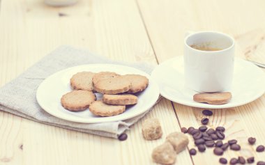 Zencefilli bisküvi, tarçın, bir fincan sıcak kahve.