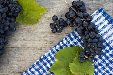 Ahşap bir masa üzerinde karanlık üzüm demet