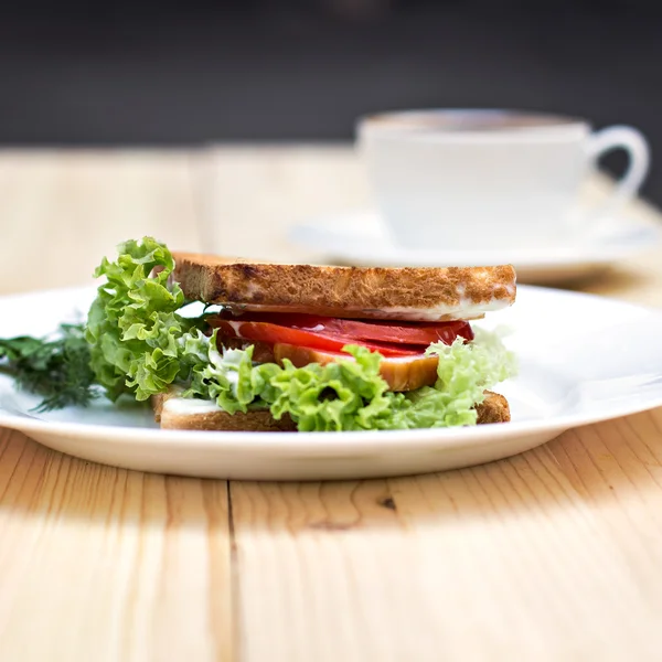 Sandwich y taza de café negro en la mesa — Foto de Stock