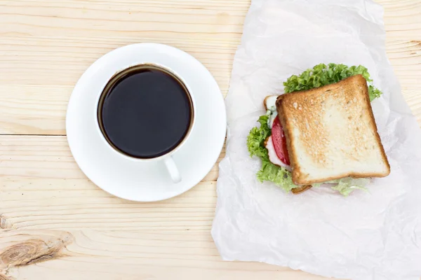Sandwich and cup of black coffee on the table — Stock Photo, Image
