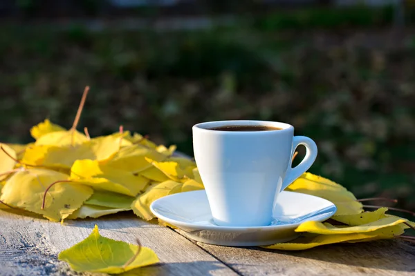 Xícara de café e folhas de outono amarelo — Fotografia de Stock