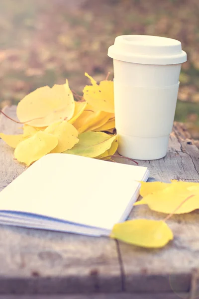 Xícara de café e folhas de outono amarelo — Fotografia de Stock