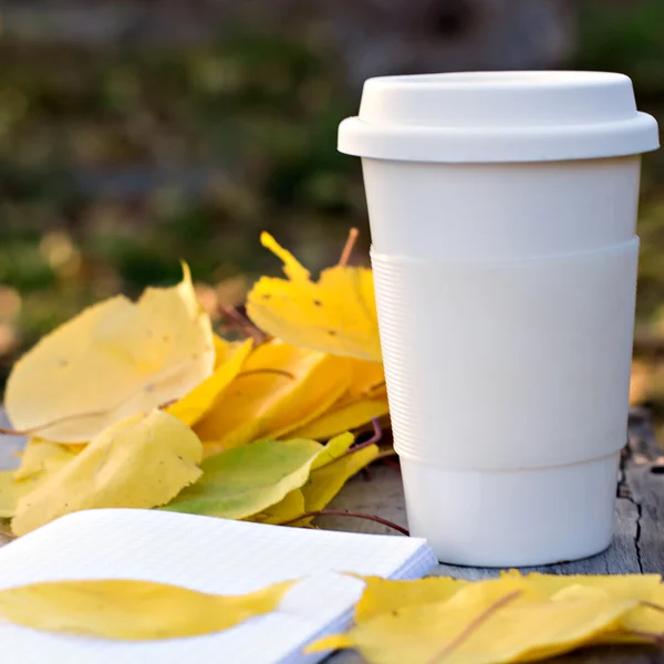 Xícara de café e folhas de outono amarelo — Fotografia de Stock