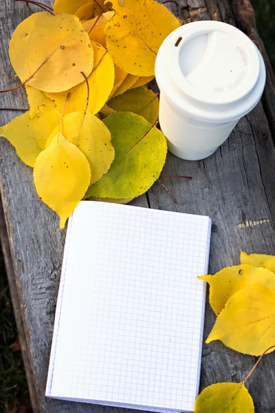 Carnet, tasse de café et feuilles d'automne jaunes — Photo