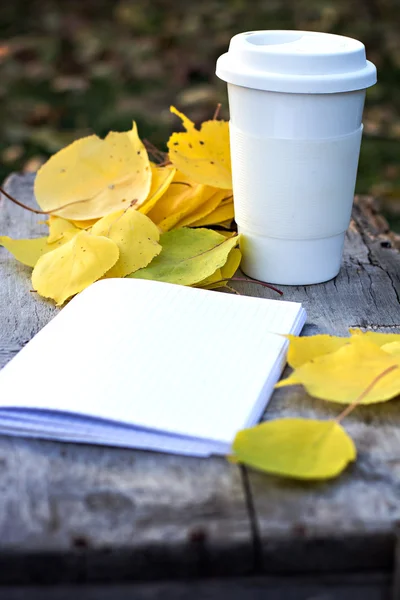 Xícara de café e folhas de outono amarelo — Fotografia de Stock