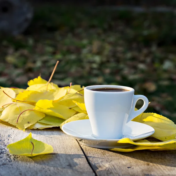 Xícara de café e folhas de outono amarelo — Fotografia de Stock