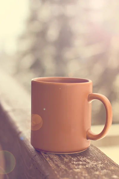 Eine Tasse mit einem heißen Getränk vor dem Hintergrund des Winterwaldes — Stockfoto