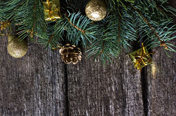 Composición navideña. Ramas de abeto y decoraciones navideñas sobre un fondo de tablas de madera — Foto de Stock