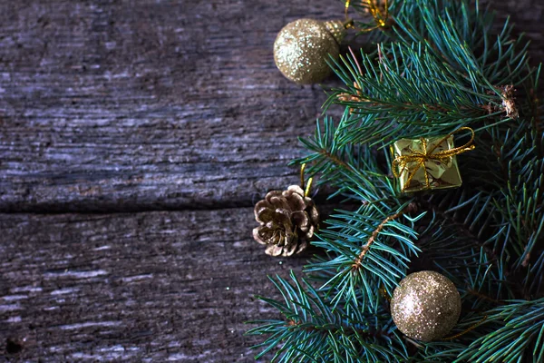 Composición navideña. Ramas de abeto y decoraciones navideñas sobre un fondo de tablas de madera — Foto de Stock