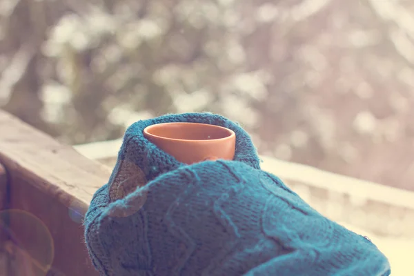 Una taza con una bebida caliente en el fondo del bosque de invierno —  Fotos de Stock