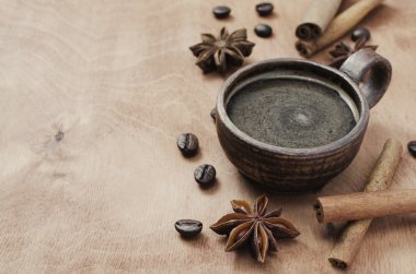 Fincan kahve, tarçın ve anason ahşap bir masa üzerinde.