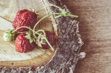 Ahşap arka plan üzerinde taze olgun organik çilek. Vintage rustik tarzı ve renk renklendirme.