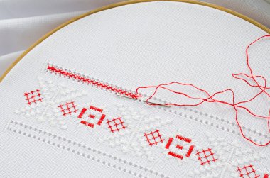 Kırmızı ve beyaz renk tuval üzerine nakış deseni ile ahşap hoop.