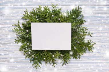 Sahte Noel tebrik kartı ve mavi ahşap arka planda köknar dalları..