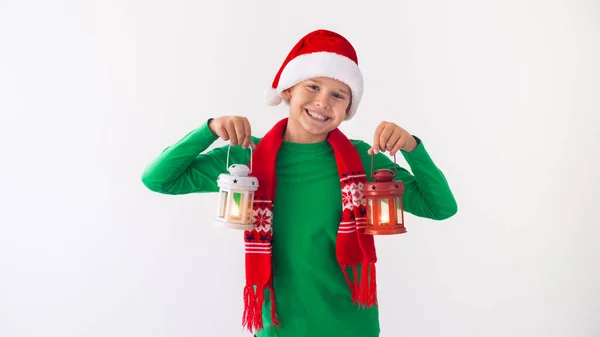 サンタクロースの帽子をかぶった幸せな男の子と手に白と赤の提灯と冬のスカーフの肖像画 クリスマスの時間に楽しんでいる子供 — ストック写真