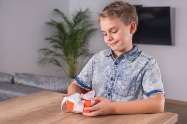 Mutlu Çocuk anneler günü ya da sevgililer günü için hediye paketi ve kart tutuyor..