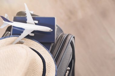 Yaşam tarzı ve seyahat konsepti, karantina pasaportları, şapka ve model uçaklar ve gri bavullar.