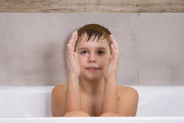 Retrato de menino brincando com xampu de sabão ou gel no banheiro Banho infantil e infla bolhas de sabão — Fotografia de Stock