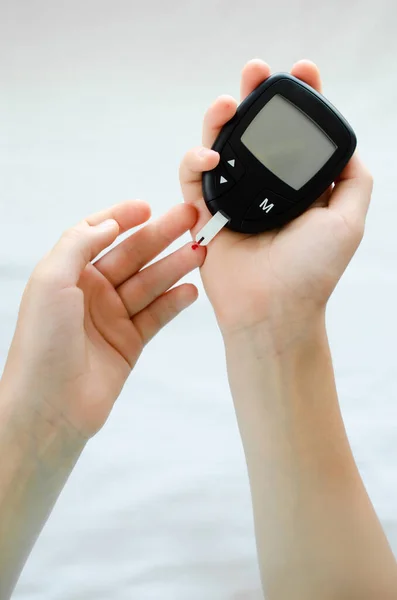 Diabetes koncept - dětský prst s kapkou krve na kontrolu hladiny cukru v krvi — Stock fotografie