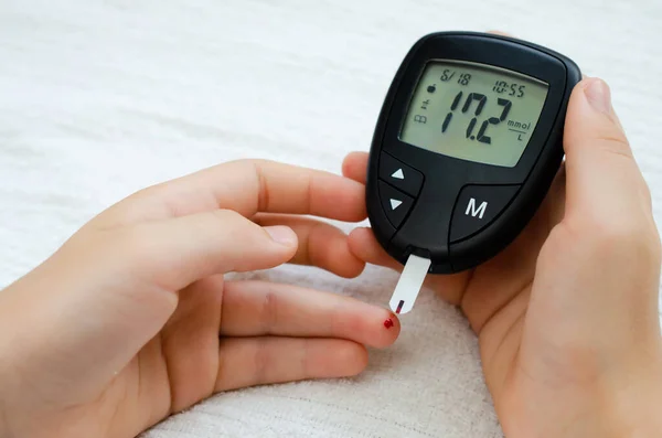 Diabetes concept - child finger with blood drop to checking blood sugar level — Stock Photo, Image