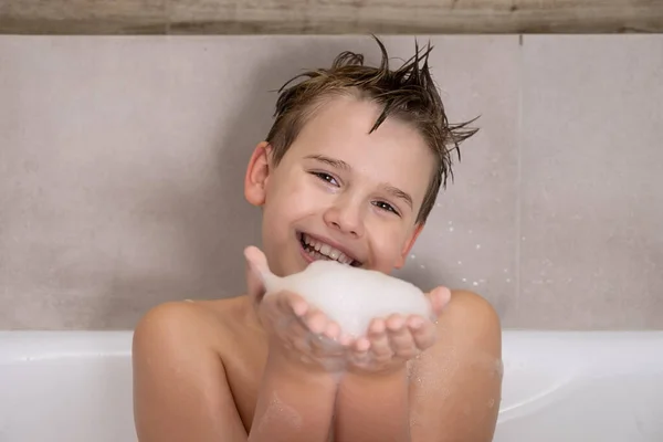 Chico divertido jugando con agua y espuma en un baño lindo niño feliz bañarse en casa infancia saludable — Foto de Stock
