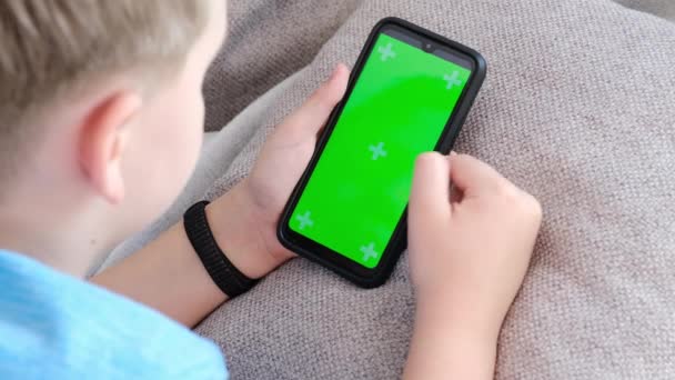 4K Boy trzyma smartfon z zielonym ekranem, przewijanie ekranu dotykowego — Wideo stockowe