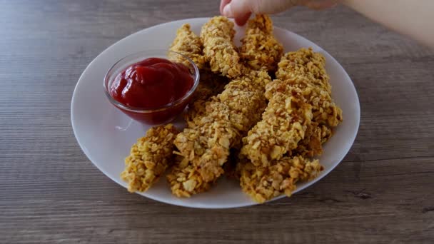 Vrouw pakt knapperig gebakken nugget van een plaat en dompelt het in ketchup. — Stockvideo