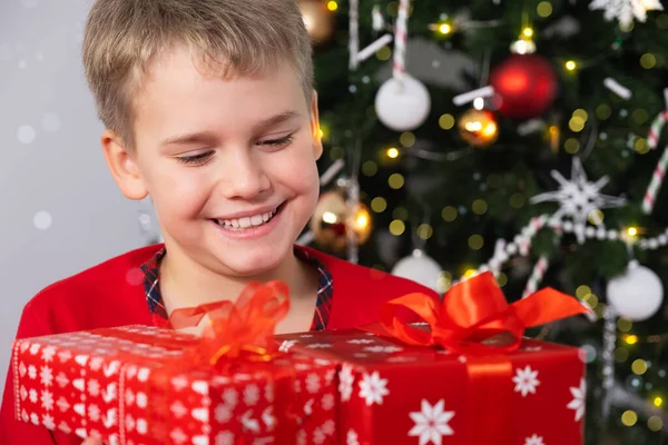 Feliz niño sonriente con cajas de regalo de Navidad cerca del árbol de Navidad. Concepto de Navidad y Año Nuevo — Foto de Stock
