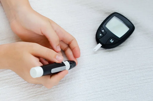 Diabetes comprobando el nivel de azúcar en sangre. Niño usando lanceleta y glucosímetro en casa —  Fotos de Stock