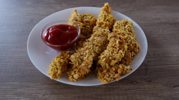 Woman picks up crispy fried nugget from a plate and dips it in ketchup. — Stock Video