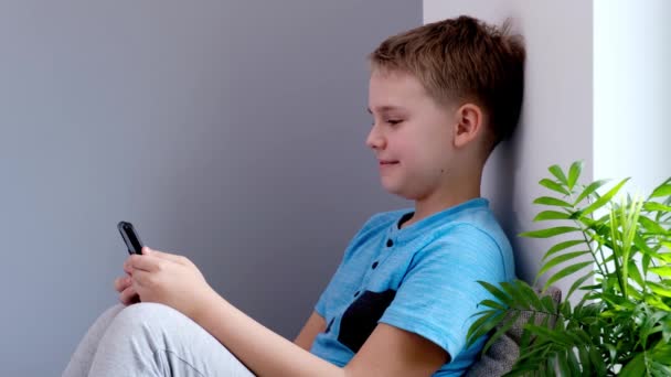 4K Positive Boy ler och pratar med videosamtal sittande på sitt rum. — Stockvideo