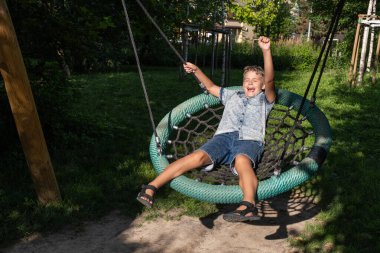 Sevimli sarışın çocuk salıncakta sallanıyor..