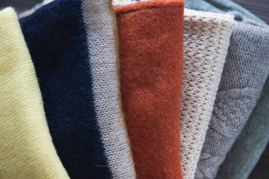 Ahşap masa üzerinde örülmüş yün elbiseler. Sonbahar veya kış arkaplanı.