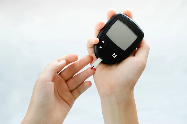 Diabetes test. Child hands checking blood sugar level by Glucose meter. — Stock Photo, Image