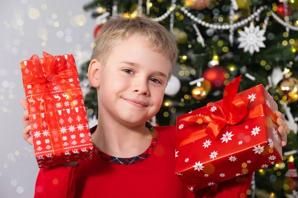 Щаслива усміхнена дитина з різдвяними подарунковими коробками біля ялинки. Новорічні та Різдвяні свята Концепція — стокове фото