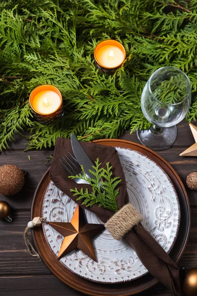 Εορταστική ρύθμιση τραπεζιού με χριστουγεννιάτικες διακοσμήσεις, κλαδιά ελάτης και κεριά σε ξύλινο φόντο. — Φωτογραφία Αρχείου