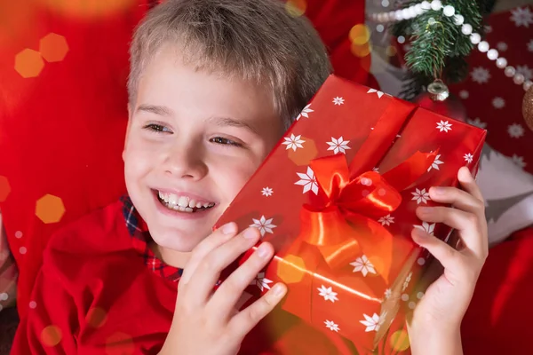 Retrato de Happy Blonde Schoolboy con regalo de Navidad en sus manos. Feliz Navidad y Feliz Año Nuevo — Foto de Stock