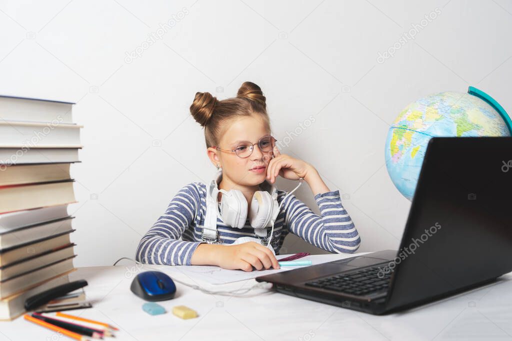 A girl in quarantine with a laptop is undergoing school training remotely.