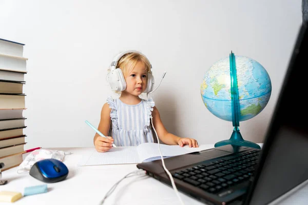 A girl in quarantine with a laptop is undergoing school training remotely.