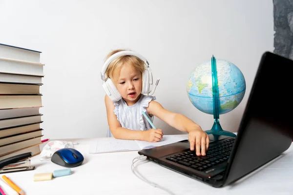 A girl in quarantine with a laptop is undergoing school training remotely.