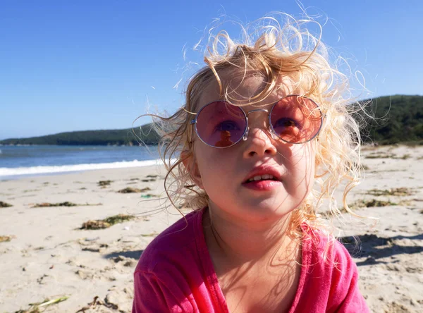 Cara de cerca de la chica divertida con gafas de sol de color rosa posando en la playa disfrutando de vacaciones de verano — Foto de Stock