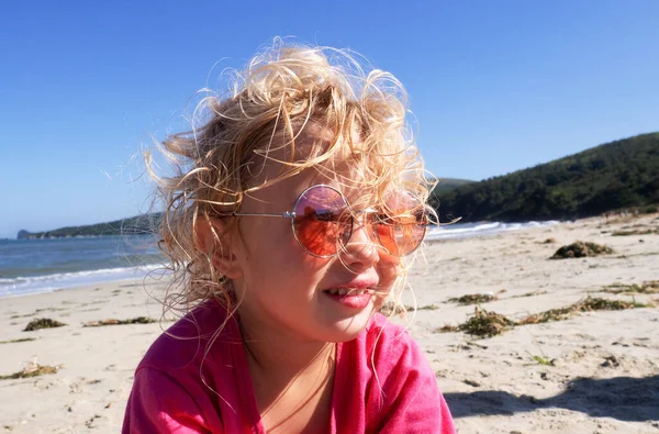 Крупный план лица смешной девушки в розовых солнцезащитных очках, позирующей на пляже, наслаждающейся летними каникулами — стоковое фото